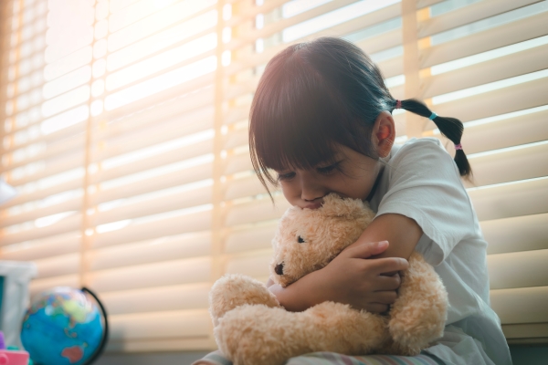 Little girl hugging teddy bear