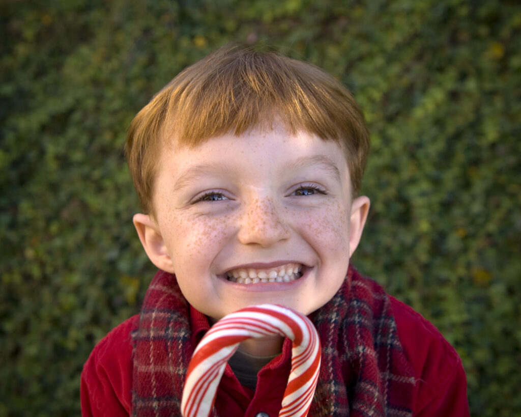 Smiling boy holding a candy cane