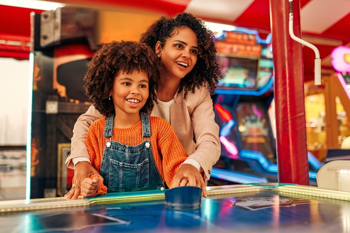 a mother having fun with her child playing air hockey